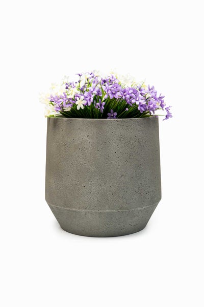 Grauer Blumentopf in Beton-Optik mit künstlichen lila und weißen Blumen.
