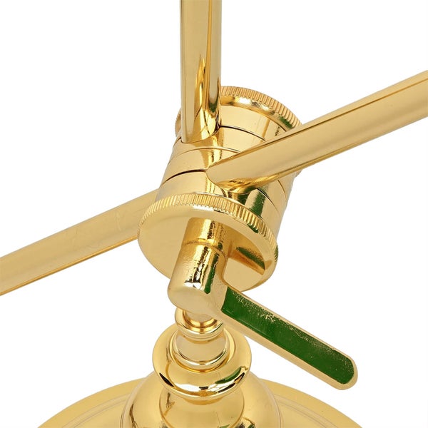 Detailaufnahme einer goldenen Lampenhalterung mit Verstellmechanismus.