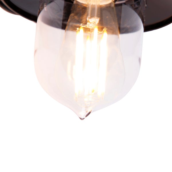 Nahaufnahme eines leuchtenden LED-Filament-Leuchtmittels in einem tropfenförmigen Glaslampenschirm.