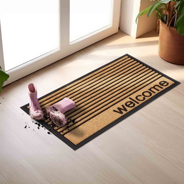 Fußmatte mit Willkommensgruß und Gummistiefeln vor einer Tür