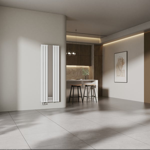 Vertikaler Design-Heizkörper mit integriertem Spiegel in einem modern gestalteten Wohnraum mit offener Küche und großformatigen Bodenfliesen.