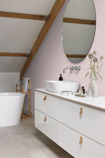 Modernes Badezimmer mit Badewanne, Waschtisch, Spiegel und Wandtapete im Fischgrätmuster.