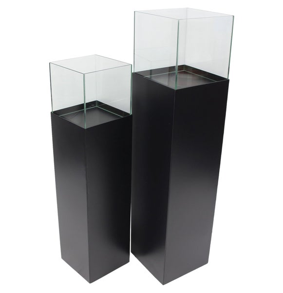 Zwei quadratische Dekosäulen aus Metall mit Glasaufsatz in unterschiedlichen Höhen für dekorative Präsentationen.