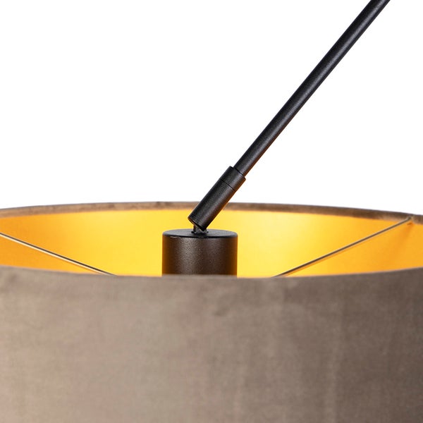 Detailansicht einer Lampenhalterung mit schwarzem Metallgestänge und Lampenschirm mit goldfarbener Innenseite.