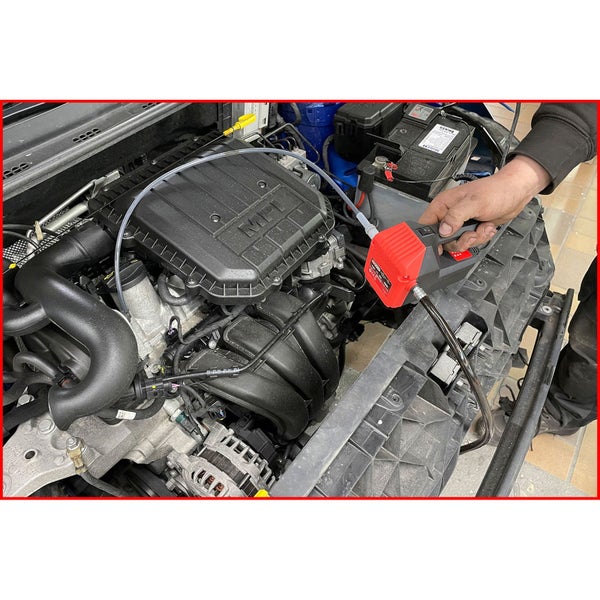 Rote elektrische Ölabsaugpumpe beim Absaugen von Motoröl aus einem Automotor.