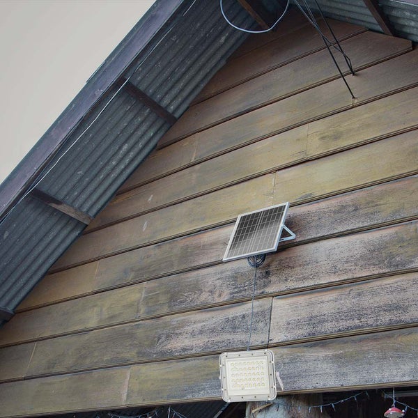 Solarpanel mit LED-Außenleuchte an einer Holzwand