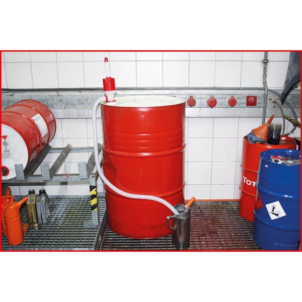 Werkstatt mit roten und blauen Fässern und Handpumpe