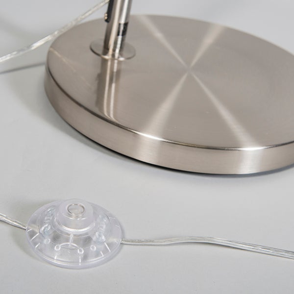 Detailansicht eines Fußschalters und des Metallsockels einer Stehleuchte.