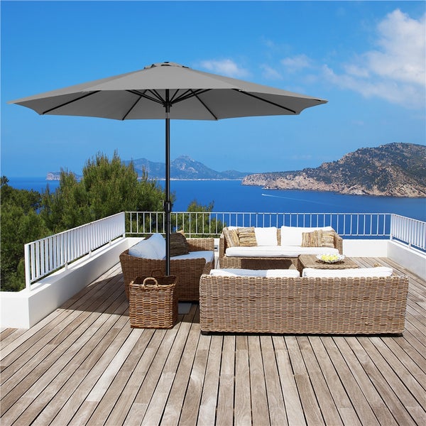 Terrasse mit Rattanmöbeln und grauem Sonnenschirm