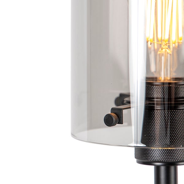 Detailansicht einer Tischleuchte mit transparentem Glasschirm und sichtbarem Leuchtmittel