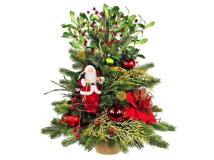 Weihnachtsgesteck mit einer Weihnachtsmannfigur, Mistelzweigen, Tannenreisig, Weihnachtskugeln und einer künstlichen Blume in einem Jutesack