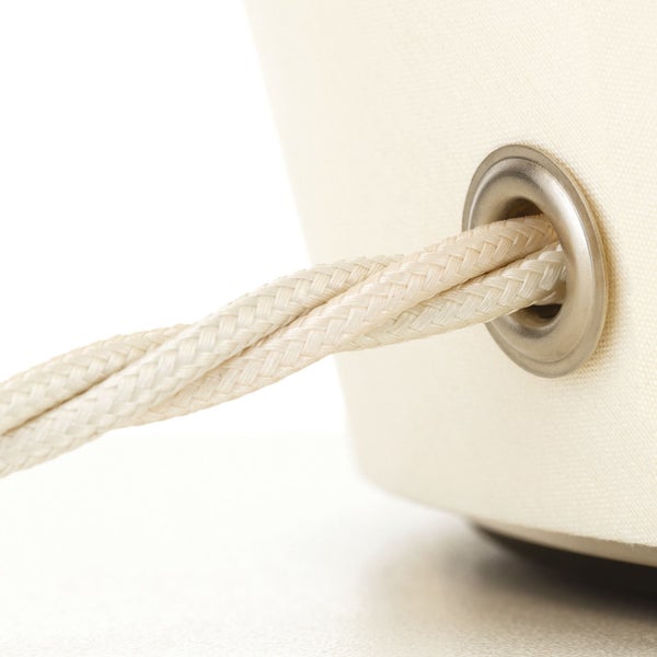 Detailansicht einer Seilkordel, die durch eine Öse in einem Textilprodukt geführt ist