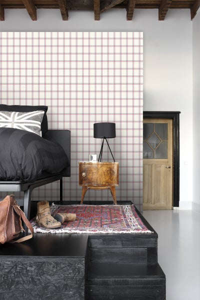 Schlafzimmer mit Bett, Nachttisch, Teppich und Tapete mit Karomuster