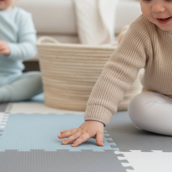 Ein Baby spielt auf einer weichen Puzzlematte aus Schaumstoff mit quadratischen, ineinandergreifenden Teilen in einem hellen Kinderzimmer.