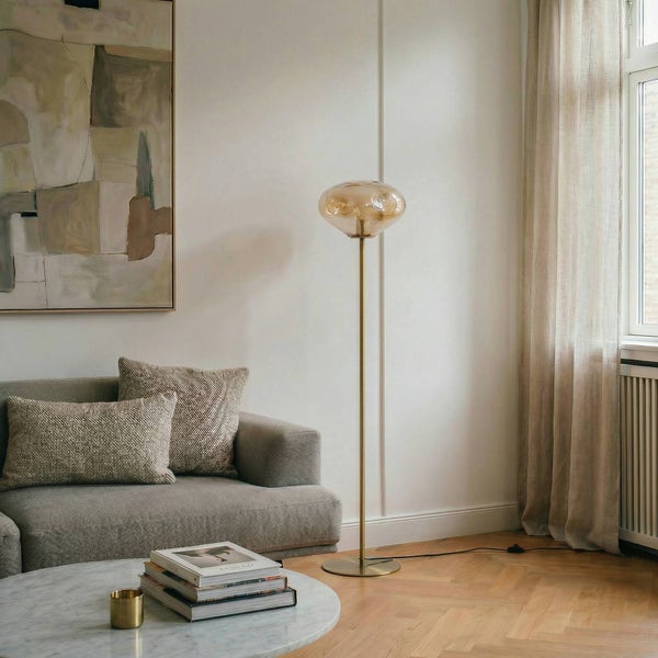 Wohnzimmer mit Sofa, Couchtisch und Stehlampe mit Glasschirm