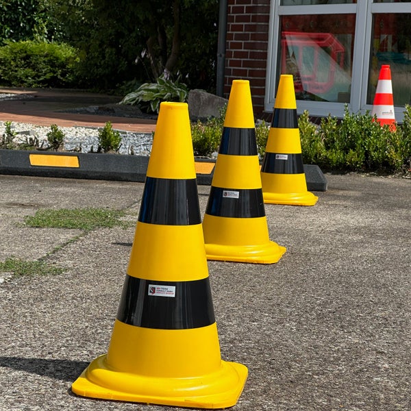 Zwei 50 Zentimeter hohe gelb-schwarze Leitkegel