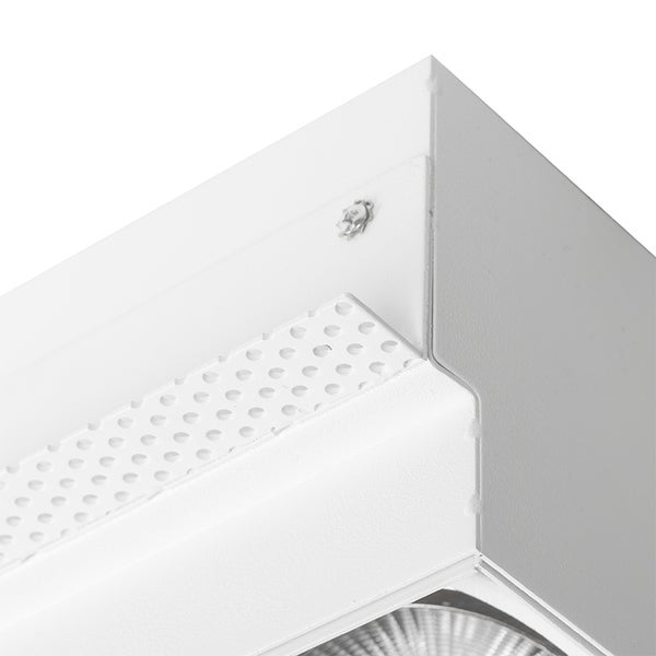 Detailansicht eines weißen rechteckigen LED Deckenstrahlers mit einer gelochten Metallplatte und Eckverbindung.