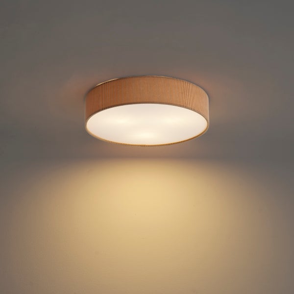 Runde Deckenleuchte mit geripptem Stoffschirm und warmem Lichtschein.