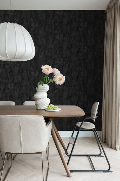 Esszimmer mit Esstisch, Stühlen, Blumenvase und schwarzer Tapete