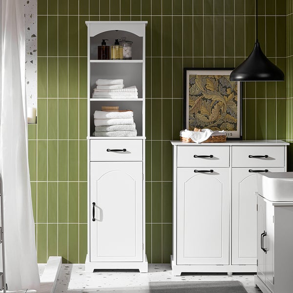 Badezimmer mit weißen Badmöbeln, darunter ein Hochschrank und ein Waschtischunterschrank vor einer grünen Wand