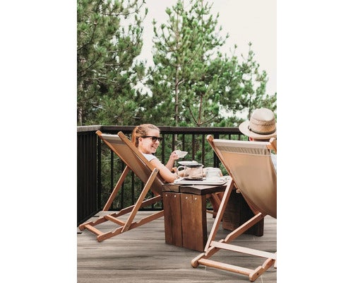 Szene auf einer Terrasse mit zwei Personen in Liegestühlen beim Teetrinken