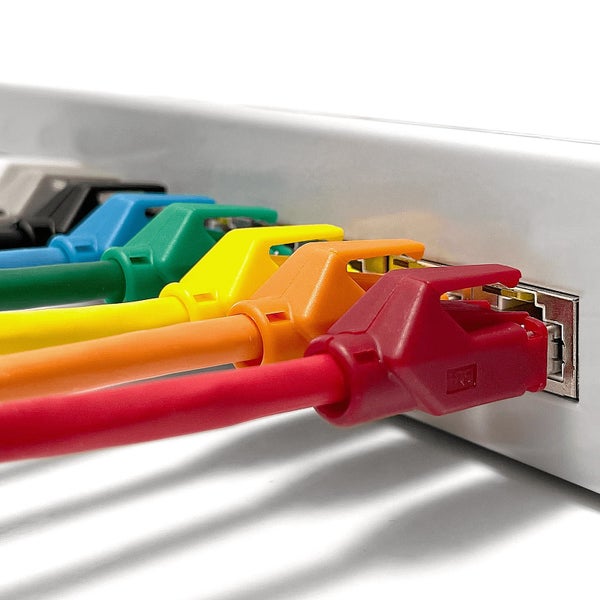 Mehrere farbige Netzwerk-Patchkabel sind nebeneinander in einen Netzwerk-Switch eingesteckt.