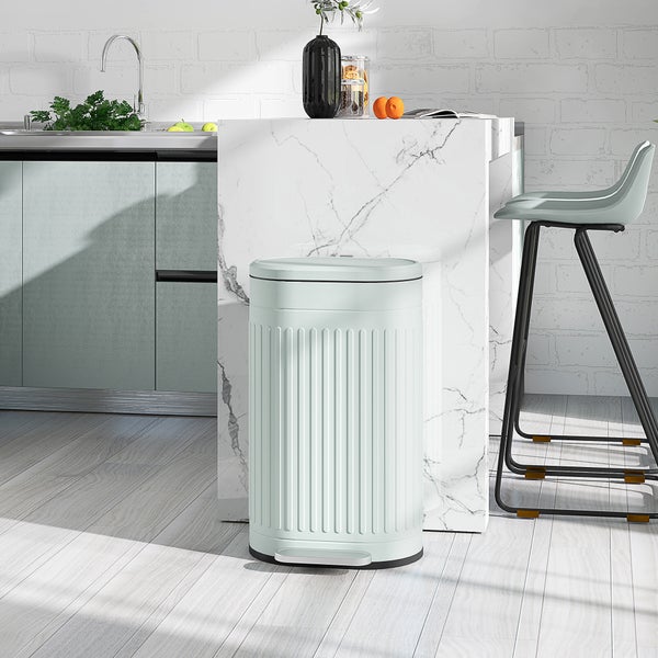 Tretabfalleimer im Retro-Stil in einer hellen, modernen Küche neben einer Kücheninsel aus Marmor und einem Barhocker.