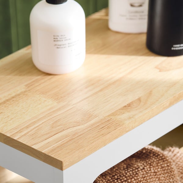 Detailansicht einer Holzplatte mit weißen Behältnissen im Badezimmer