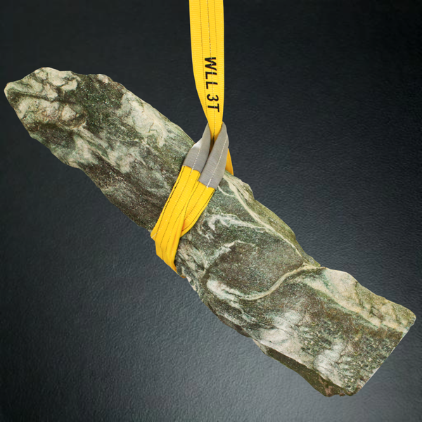 Naturstein-Stele wird von einer Hebeschlinge mit einer Tragfähigkeit von 3 Tonnen angehoben.