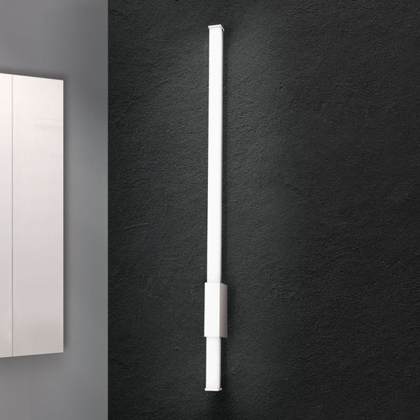 Moderne LED Wandleuchte in stabform als Badezimmerleuchte an einer Wand montiert neben einem Spiegel