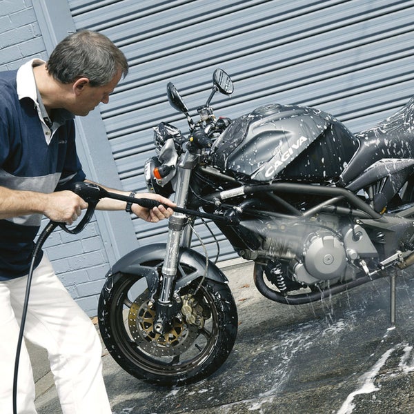 Rechteckiger Jute-Teppich mit kreisförmigem Flechtmuster in einem hellen Wohnzimmer mit modularem Sofa und Sideboard aus Holz.
