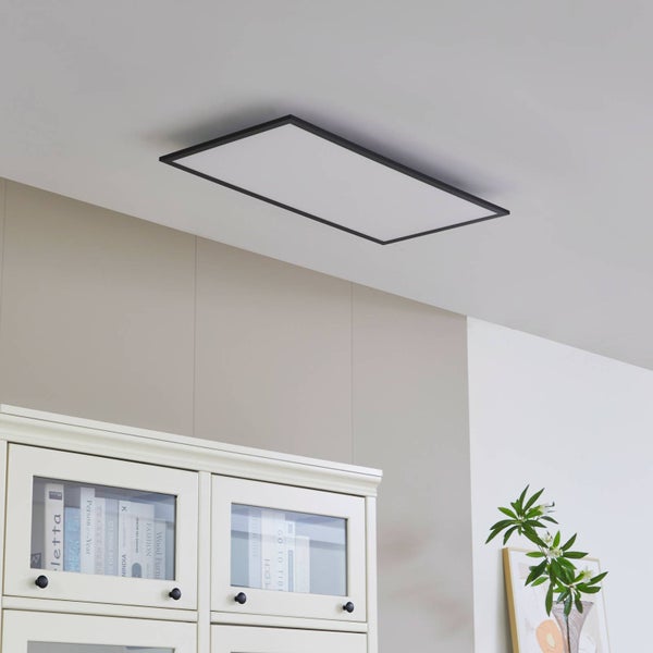 Moderne, rechteckige LED-Panel-Deckenleuchte mit schmalem schwarzem Rahmen in einem hellen, aufgeräumten Wohnraum über einem Schrank.