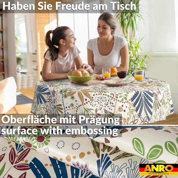 Runde Tischdecke mit buntem Blumenmuster in heller Esszimmer-Szene. Detail der geprägten Oberfläche. ANRO Logo.