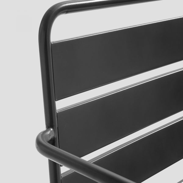 Detail einer Stuhlrückenlehne aus Metall mit Rundrohrrahmen und horizontalen Lamellen.