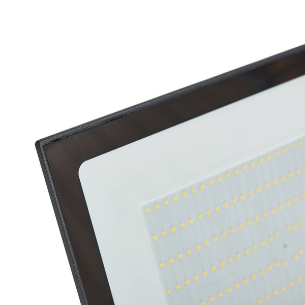 Nahaufnahme eines LED-Flutlichts mit schwarzem Rahmen und in Reihen angeordneten gelben LED-Chips auf einer weißen Fläche.