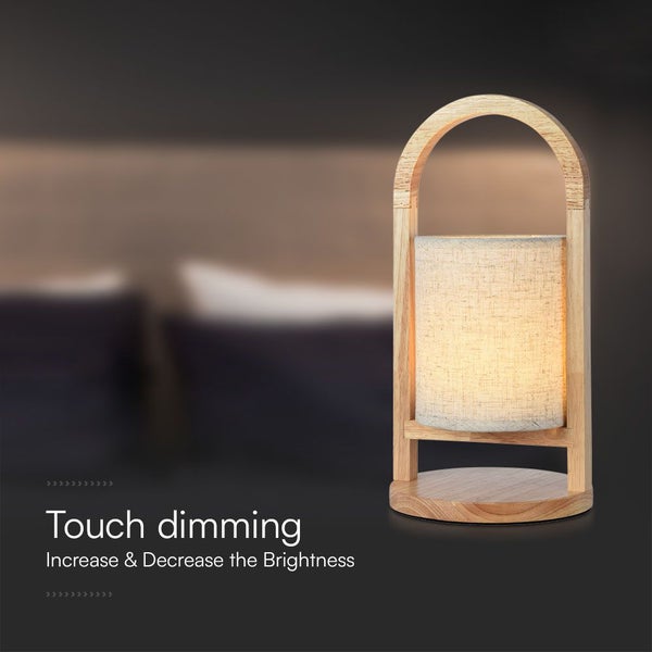 Tischleuchte aus Holz mit hellem Stoffschirm und Touch-Dimmfunktion zur Helligkeitsregulierung.
