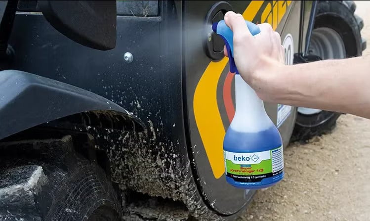 Anwendung von beko Super Kraftreiniger 1 zu 3 auf einer verschmutzten Baumaschine mittels Sprühflasche.