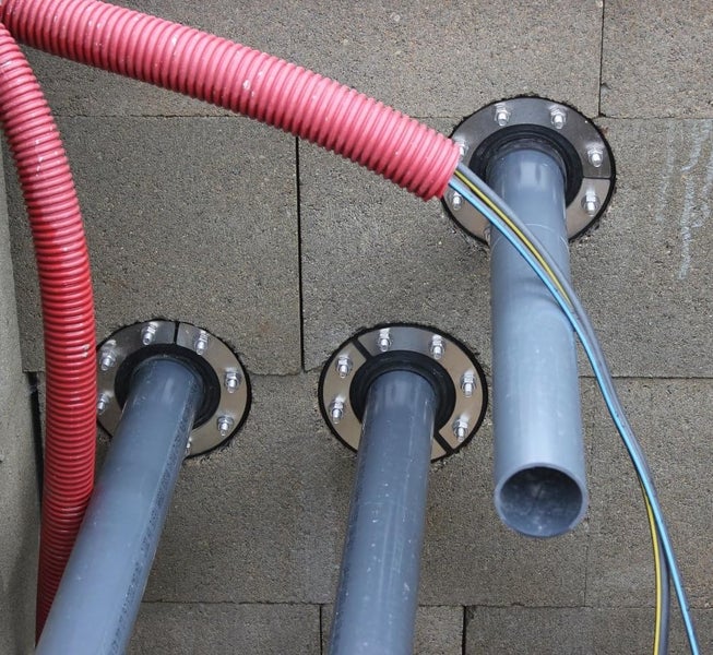 Rohrdurchführung für Kabel und Leerrohre durch eine Mauer mit Flanschbefestigung
