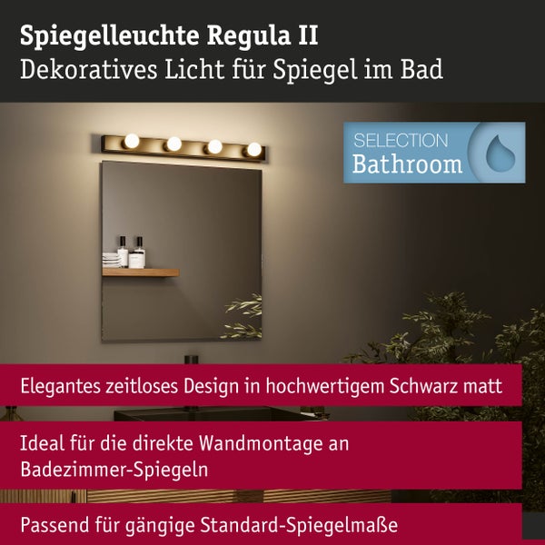 Badezimmerspiegel mit der mattschwarzen Spiegelleuchte Regula II, vierflammig, direkt über dem Spiegel an der Wand montiert.