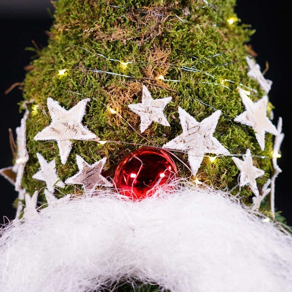 Nahaufnahme eines Moos-Weihnachtsbaums mit Sternen, Lichterkette und Christbaumkugel