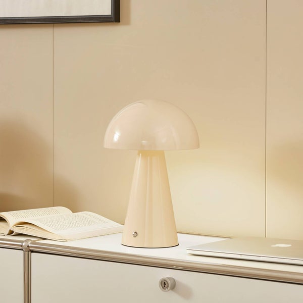 Moderne pilzförmige Tischleuchte auf einem Sideboard neben einem Buch und einem Laptop. Minimalistisches Design, glänzende Oberfläche.