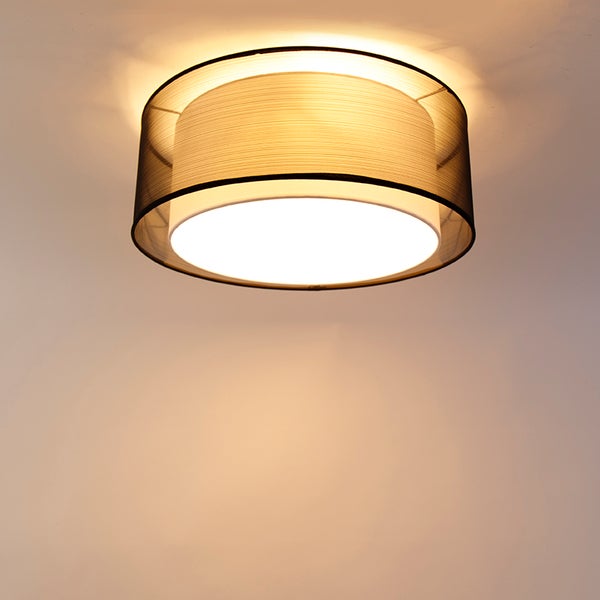 Runde Deckenleuchte mit doppeltem Textilschirm, dunkles Netzgewebe außen und heller Diffusor innen, eingeschaltet.