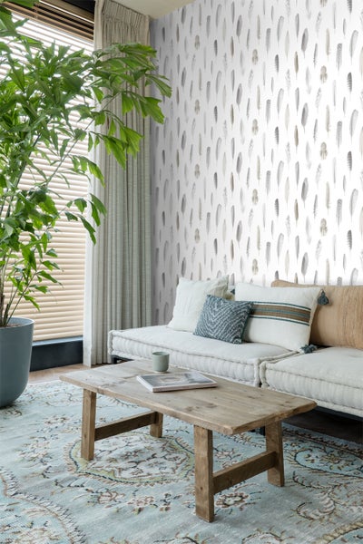 Wohnzimmer mit Feder Tapete, Sofa, Holztisch und Zimmerpflanze