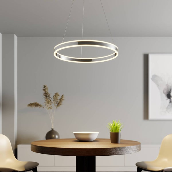 Moderne LED-Pendelleuchte in Ringform über einem runden Holztisch in einem hellen, minimalistischen Esszimmer.