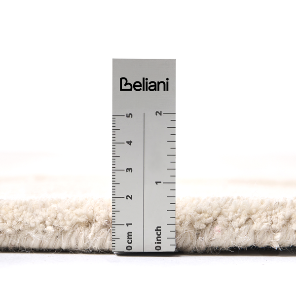 Florhöhe eines cremefarbenen Teppichs gemessen mit einem Beliani Lineal. Das Lineal zeigt Zentimeter und Inch. Beliani Logo.