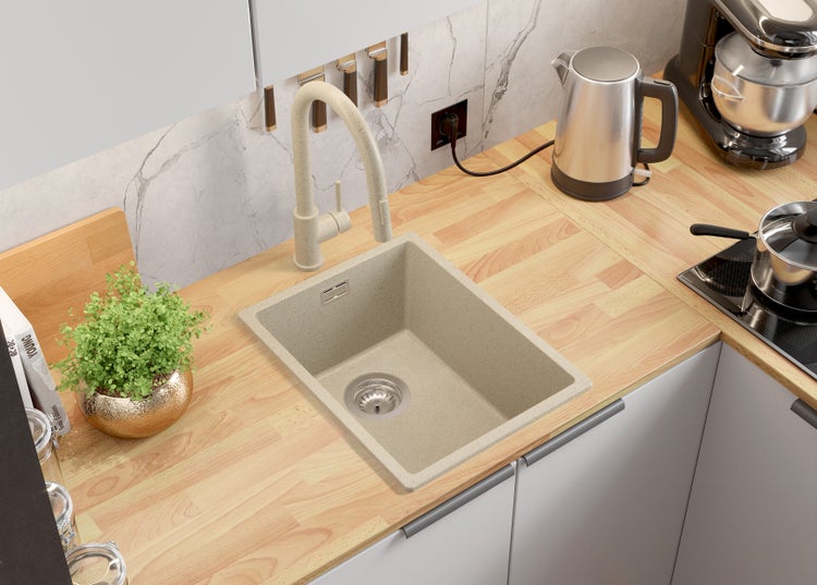 Küchenszene mit Spüle, Armatur, Arbeitsplatte und Küchengeräten.