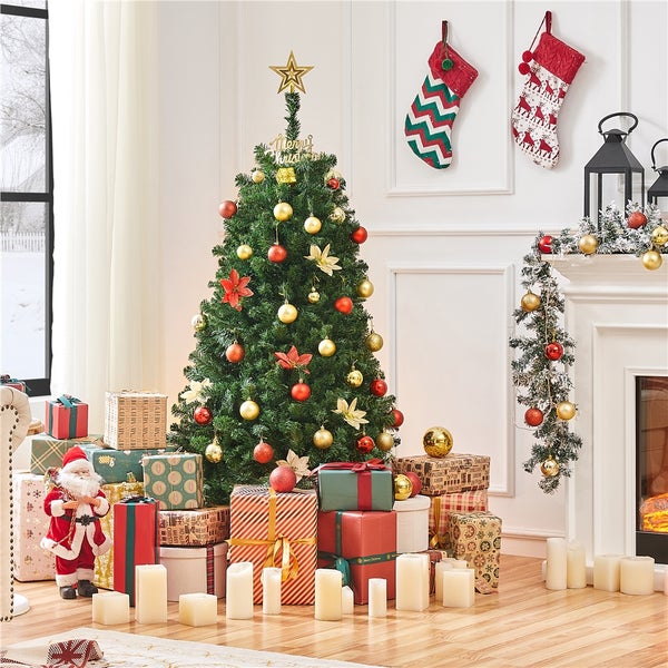 Dekorierter Weihnachtsbaum mit Geschenken und Dekoration in einem Wohnzimmer.