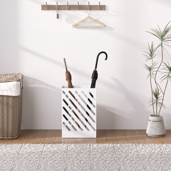 Moderner weißer Regenschirmständer mit diagonalem Muster in einem hellen Flur mit Holzboden, Pflanze und Flechtkorb.