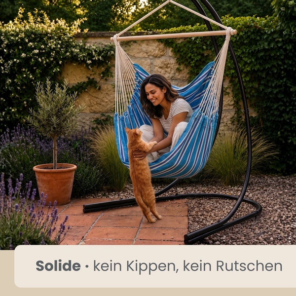 Frau sitzt in einem stabilen Hängesessel mit Gestell und streichelt ihre Katze in einem Garten mit Terrasse und Pflanzen.