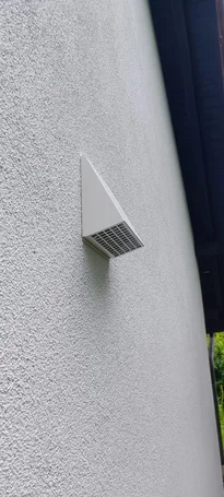 Dreieckige Dunstabzugshaube an einer Fassade